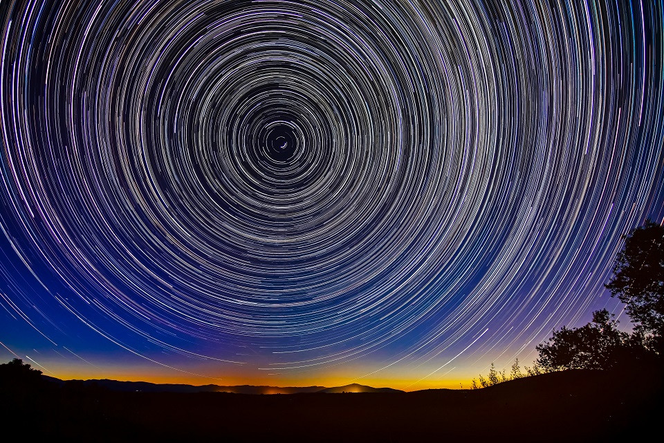 stars spiralling outwards in the night sky